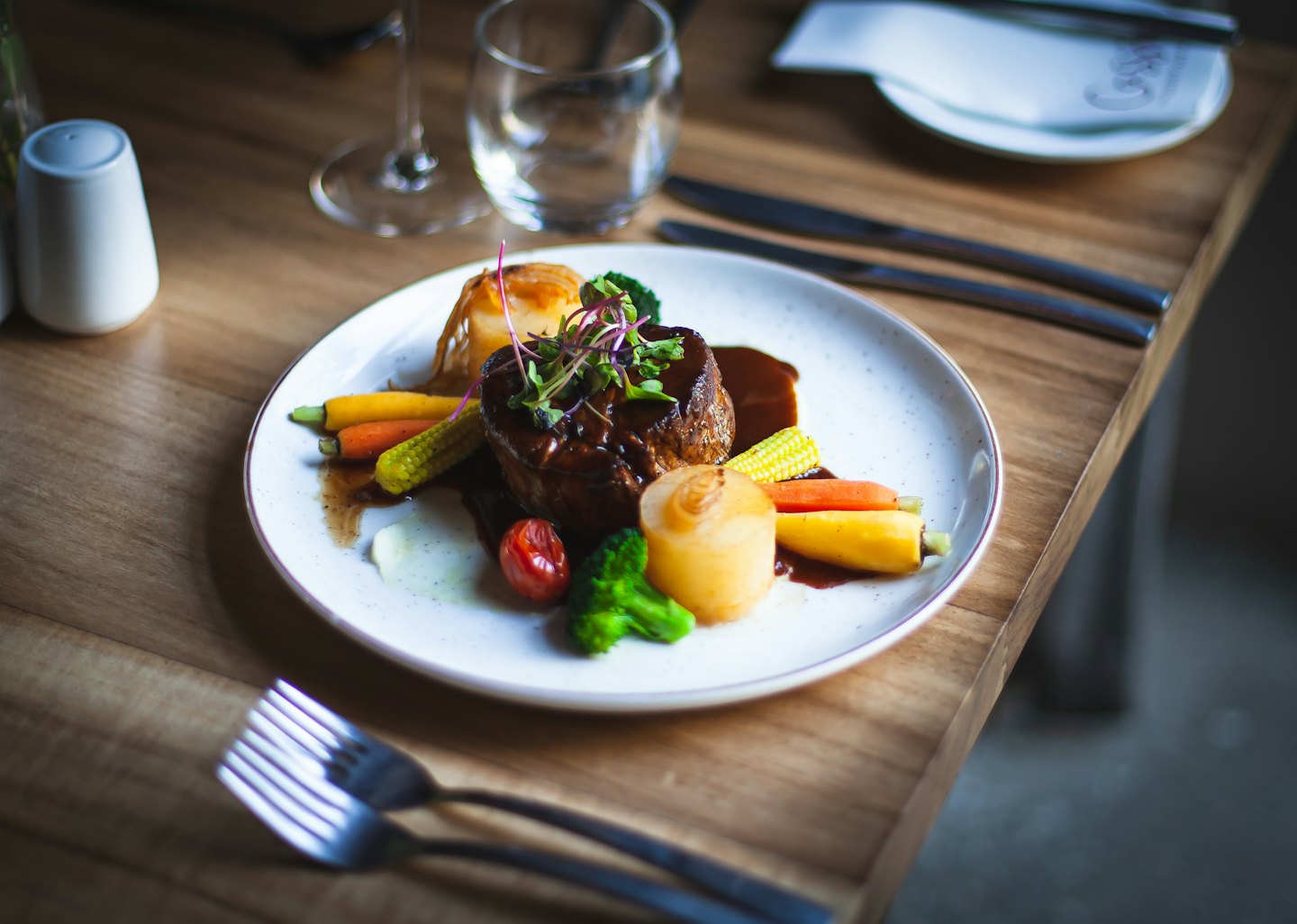 Gourmet-Steak mit Gemüse auf einem weißen Teller.