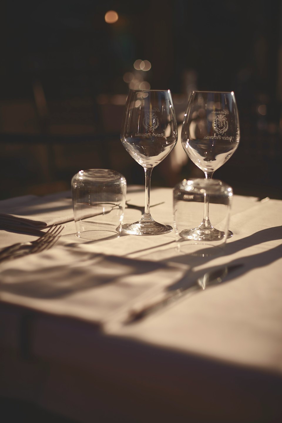Wein- und Wassergläser auf einer weißen Tischdecke.